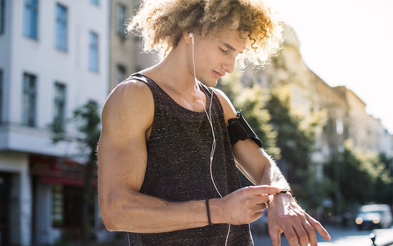 Mann überprüft seine Herzfrequenz beim Cardio Training mit einer Sportuhr