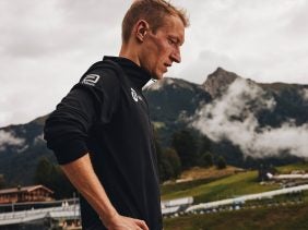 Marathon runner, Björn Koreman stands with mountains and fog behind him.