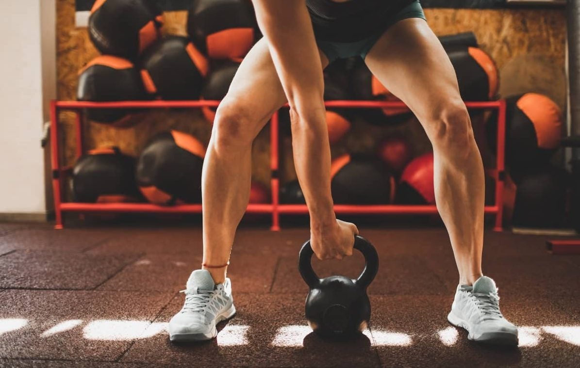 woman doing an exercise with a kettleball